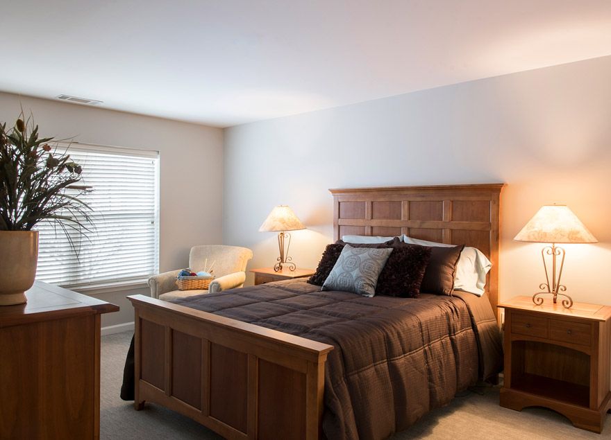 A cozy bedroom with a wooden bed and warm lighting.