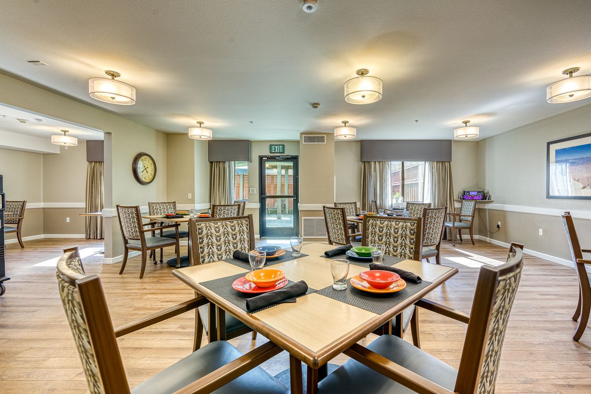 A well-lit dining area with neatly arranged tables and chairs, featuring modern decor.