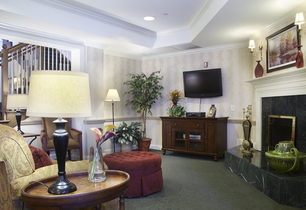 A cozy living room with a TV, lamps, and comfortable seating.