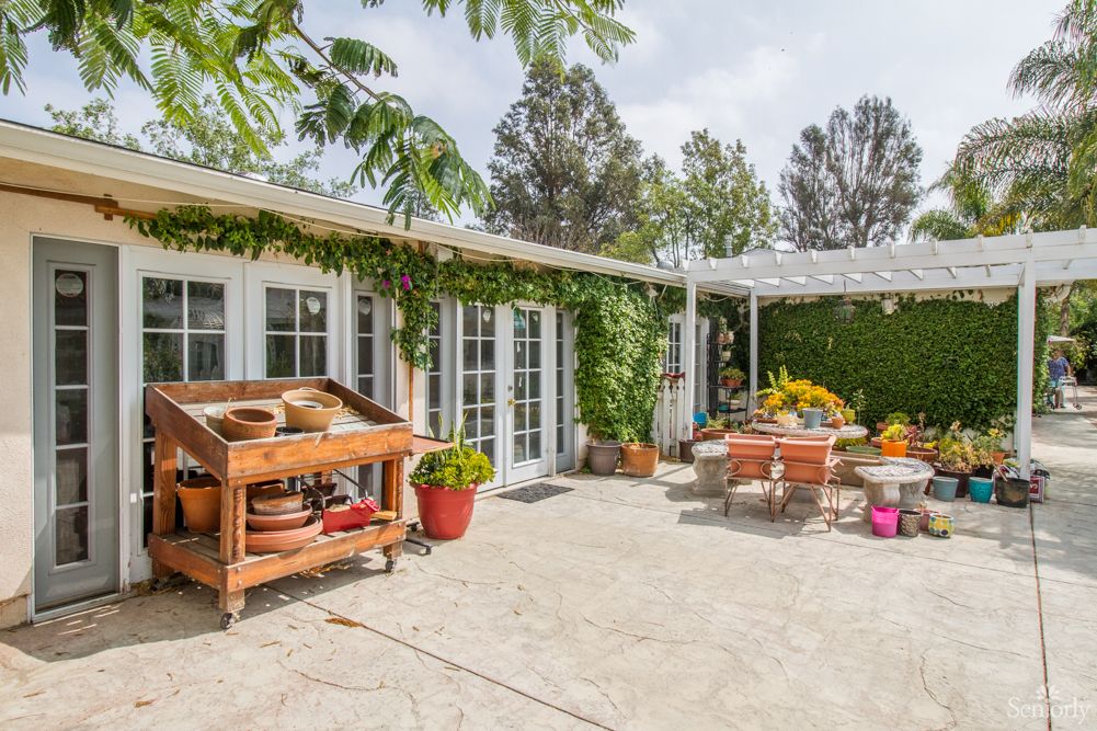 A cozy patio area with garden furniture and lush greenery.