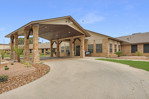 Welcoming entrance of a residential facility surrounded by landscaped grounds.