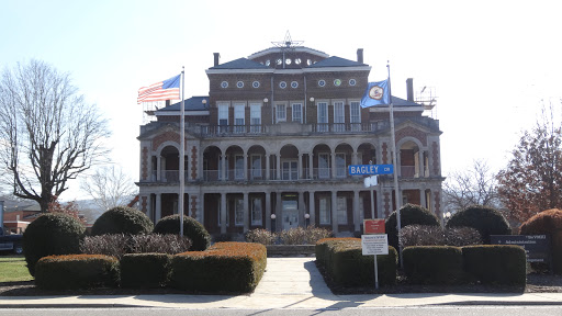 An elegant historic building featuring multiple flags, showcasing classic architectural design.