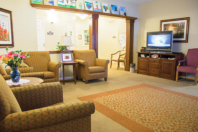A cozy living room with comfortable seating, a television, and elegant wooden furnishings.