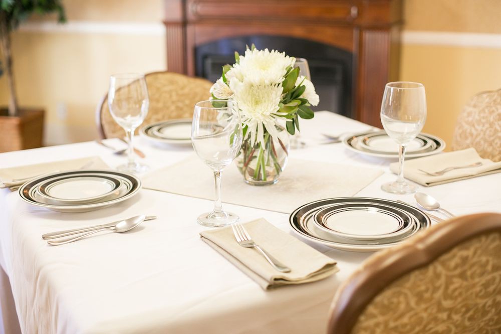 An elegantly set dining table with floral centerpiece.