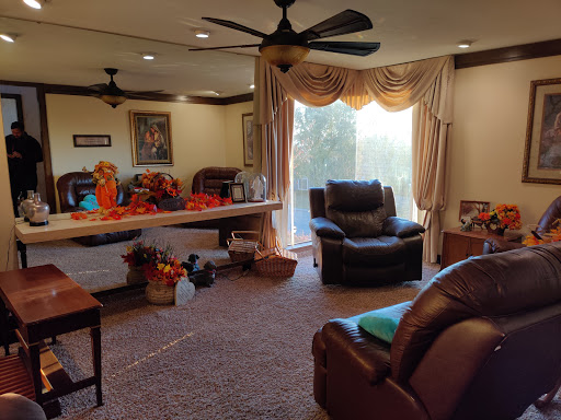 A cozy living room featuring a recliner, decorative elements, and natural light flowing in through a window.