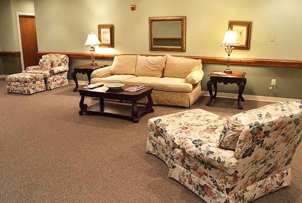 A cozy living room with floral-patterned furniture and warm lighting.