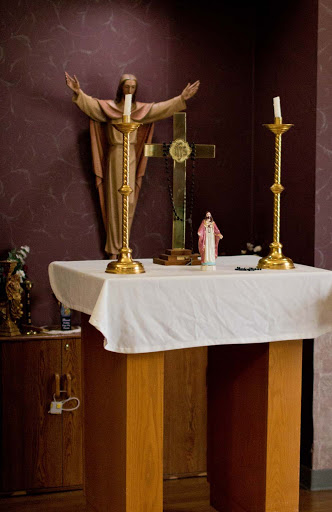 A beautifully arranged altar featuring a crucifix, candles, and decorative statues.