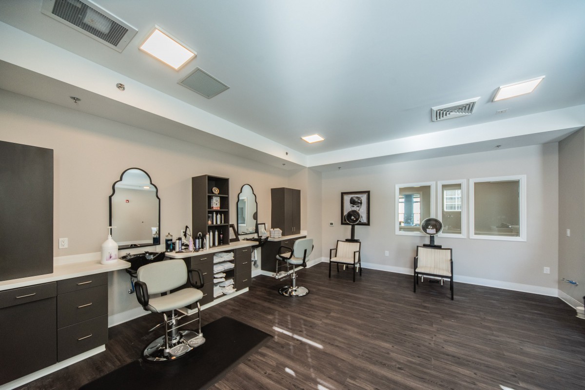 A modern salon interior with chairs and mirrors arranged for hairstyling.