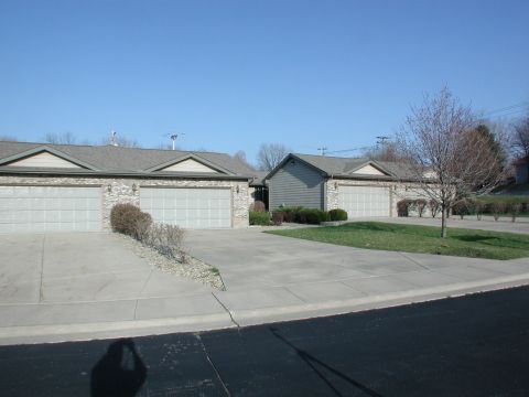 A suburban neighborhood scene featuring two houses with garages and driveways.