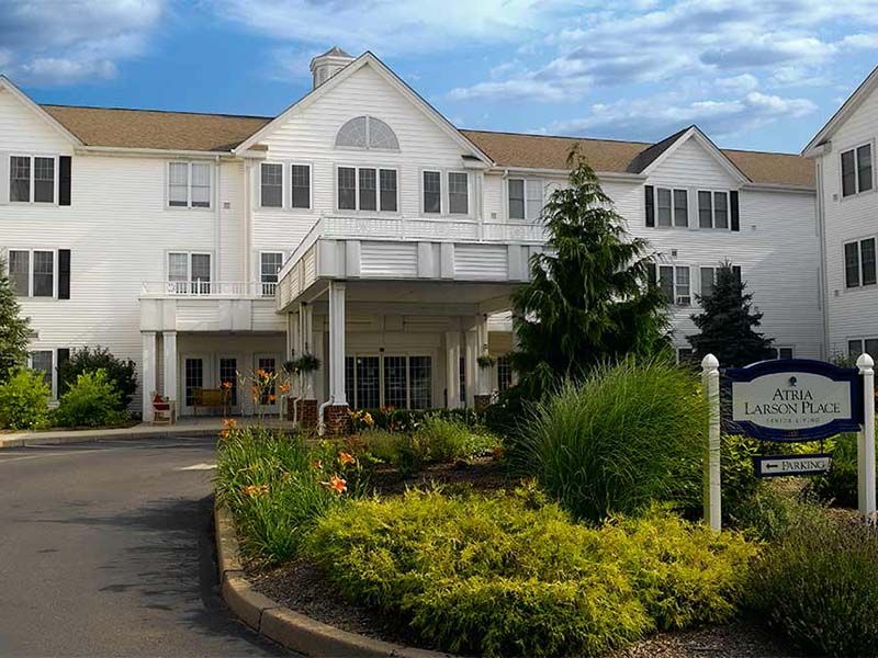A scenic view of a hotel's exterior with well-maintained landscaping and clear blue skies.
