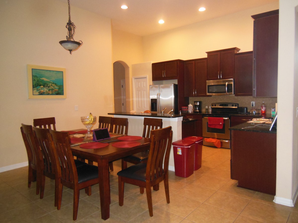 A modern open-concept kitchen and dining area featuring wooden furniture and stainless steel appliances.