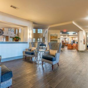 A modern hotel lobby with comfortable seating and a reception desk.