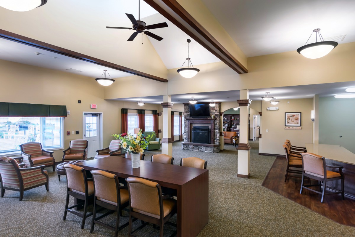 Spacious dining area with a large table, chairs, ceiling fan, and fireplace.