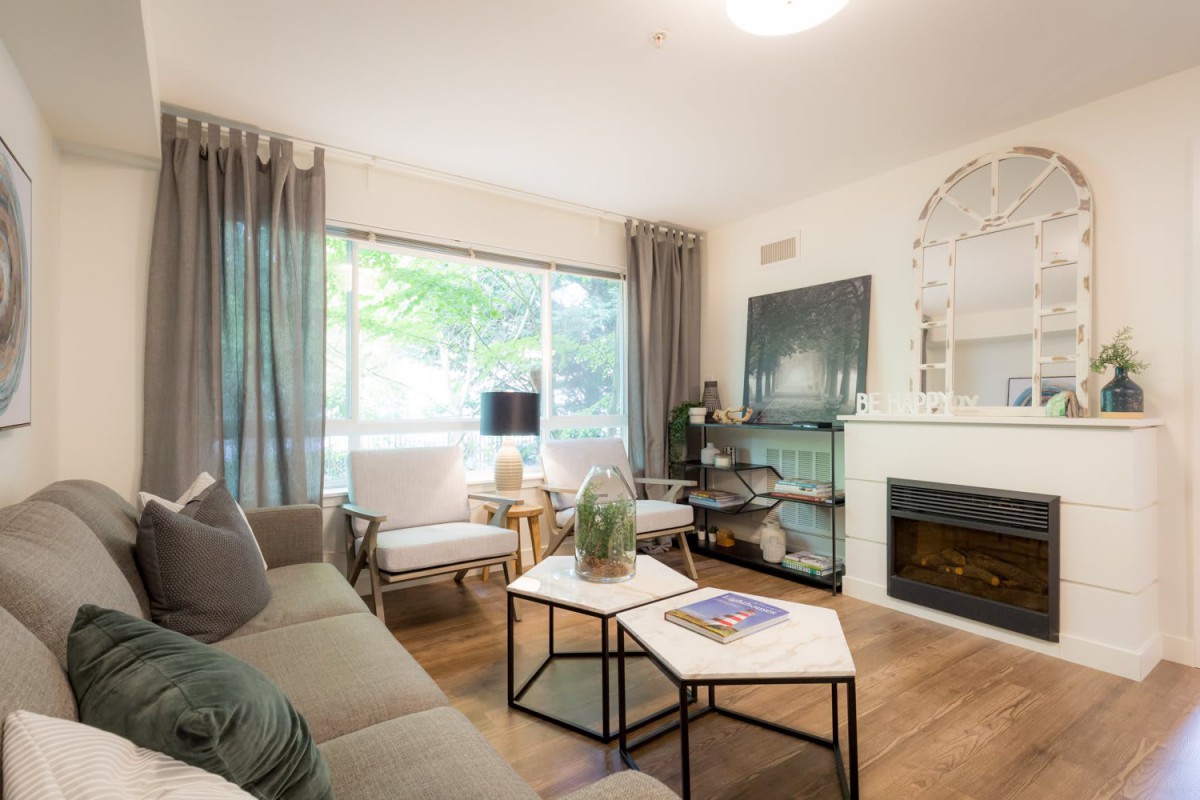 A modern living room with stylish decor, featuring a fireplace, a comfortable sofa, and a coffee table set on a wooden floor.