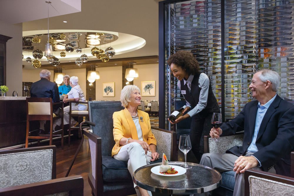 A group of people enjoying a conversation in a restaurant while a waitress takes their order.
