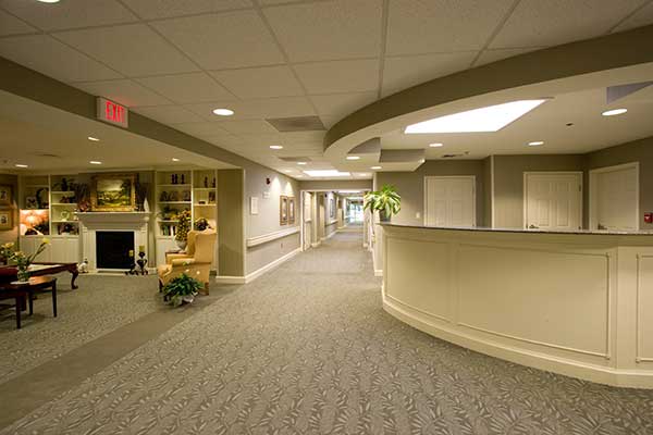 A modern office hallway with a reception area and seating.