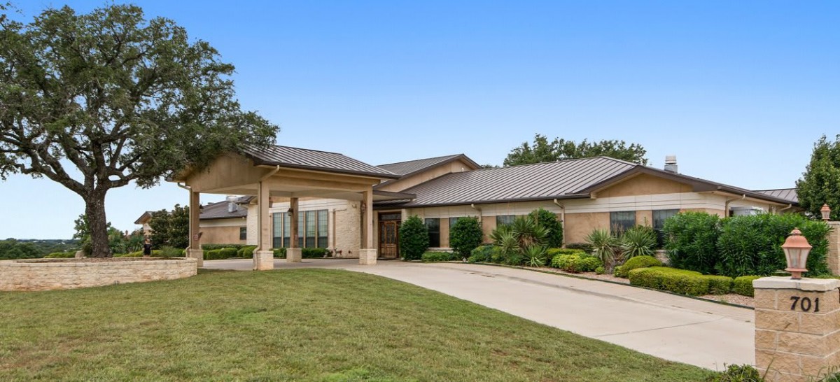 A modern single-story house with a driveway and landscaped front yard.