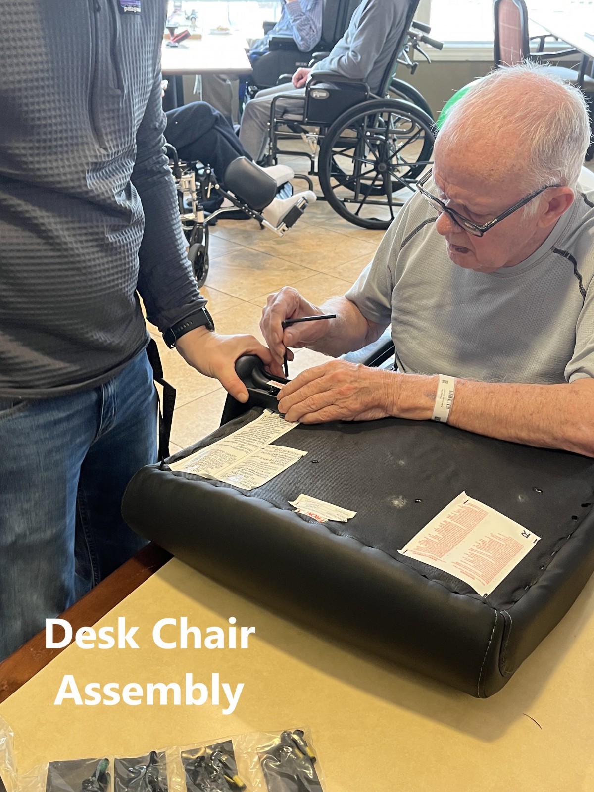Two people collaborate to assemble a desk chair.