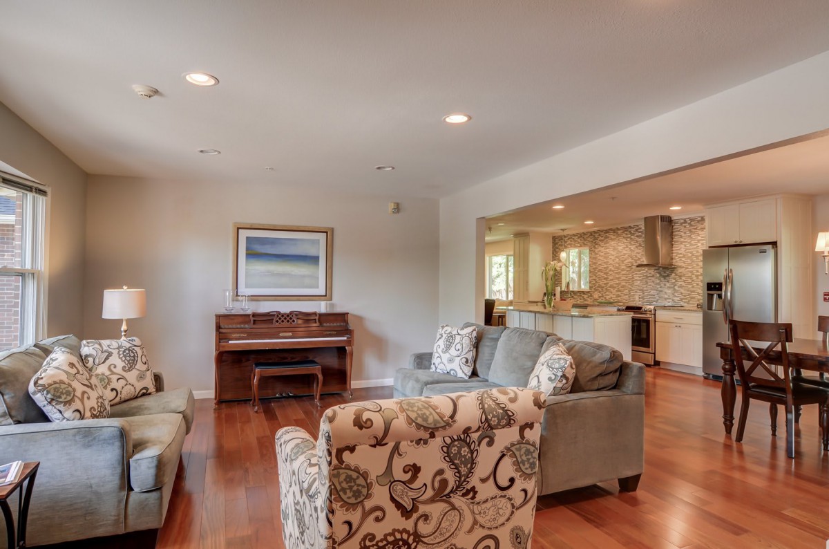 A cozy living room with elegant furniture and a view into the kitchen.