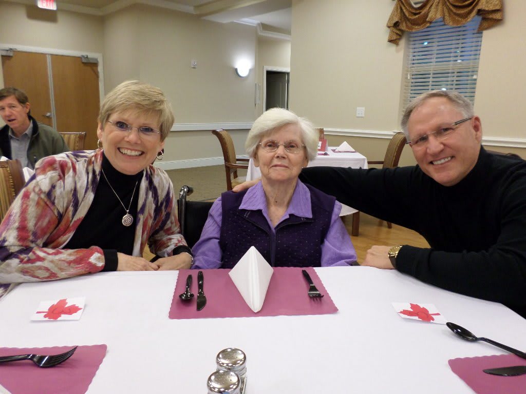 A group of three people enjoying a meal together at a dining table.