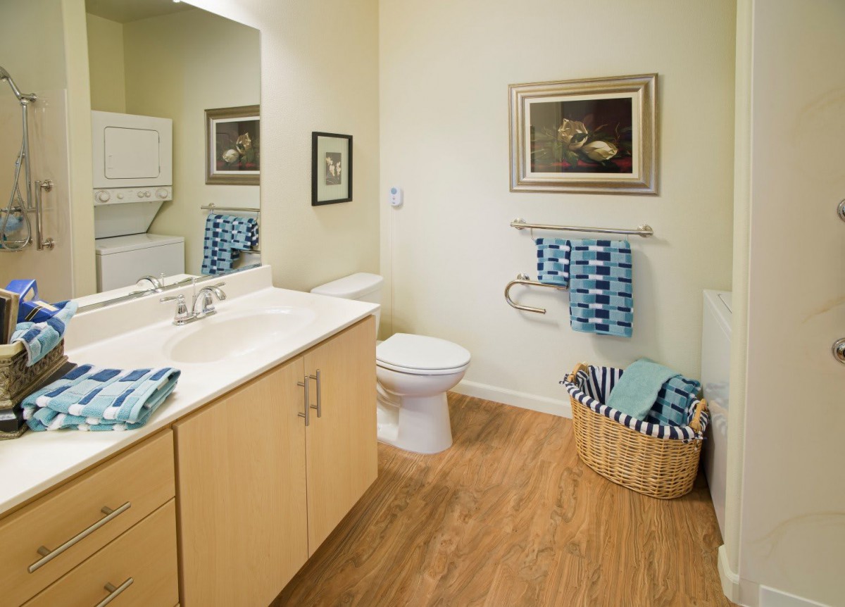A neatly organized bathroom with a sink, toilet, and decorative elements.