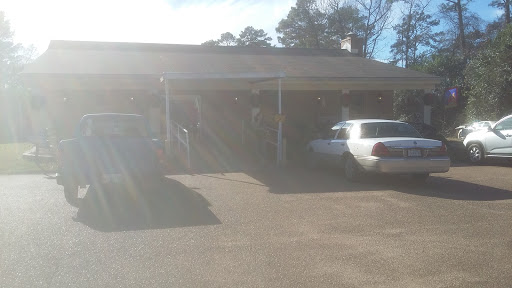 A sunny day view of a building with parked cars in the foreground.