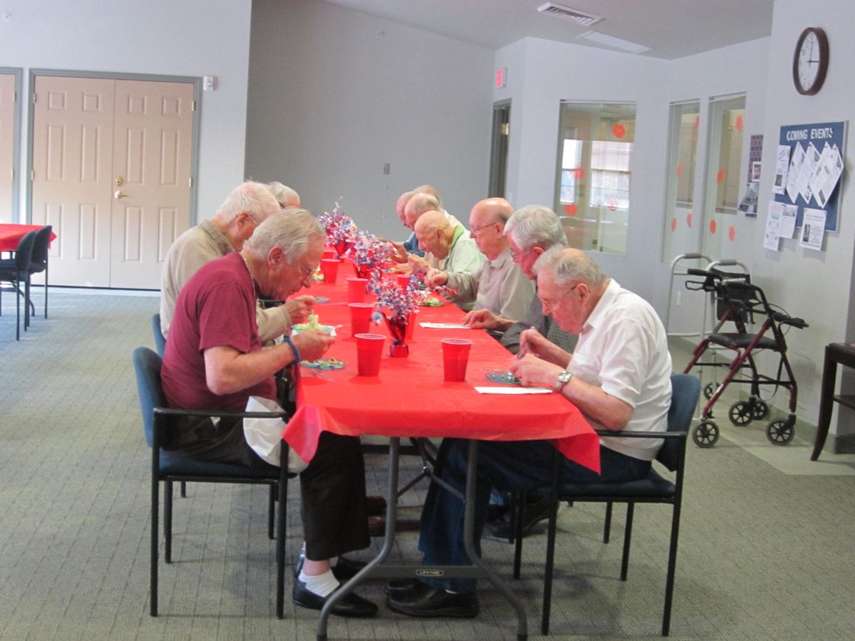 A group of elderly individuals enjoying a meal together at a community event.