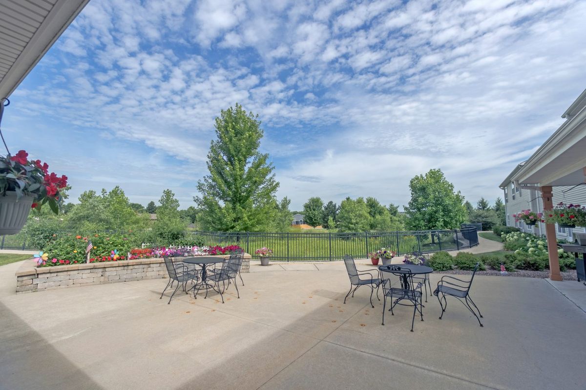 Outdoor patio area with tables and chairs overlooking a scenic landscape.