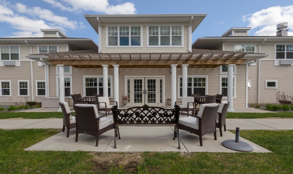A spacious patio with outdoor seating in front of a large house.