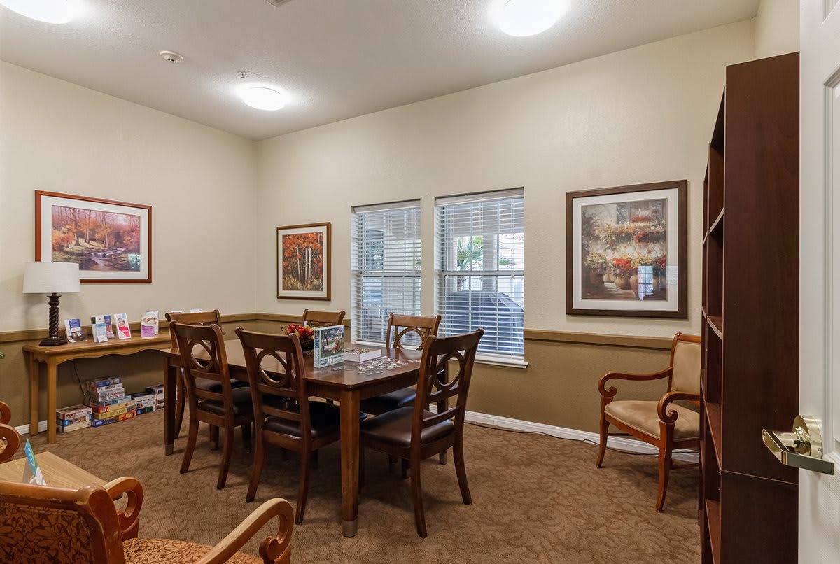 A cozy dining room with a wooden table, chairs, and framed artwork on the walls.