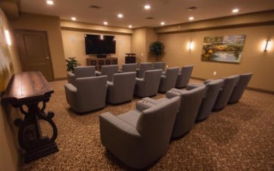 A cozy home theater setup featuring multiple armchairs facing a large screen.