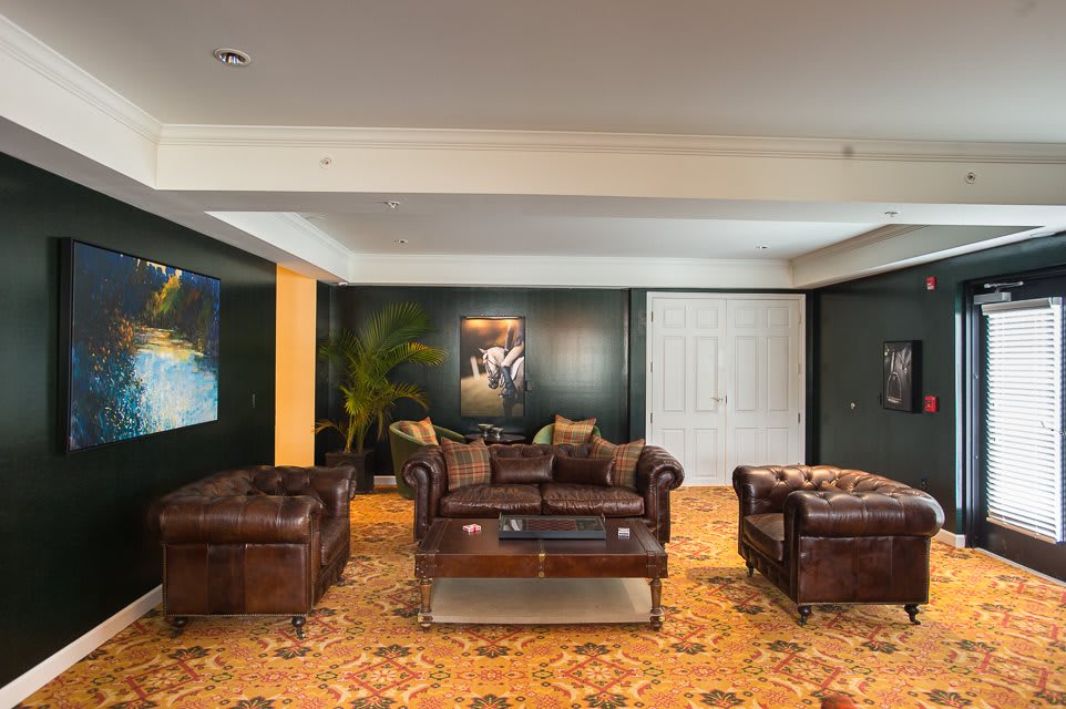 A cozy living room with leather sofas and a decorative carpet.