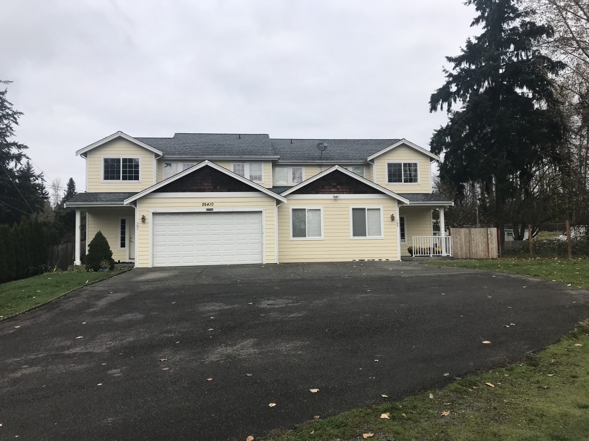 A two-story suburban house with a garage and driveway.