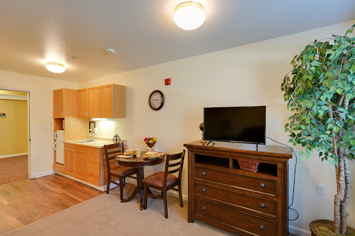 A cozy apartment interior featuring a small kitchen, dining area, and living space.