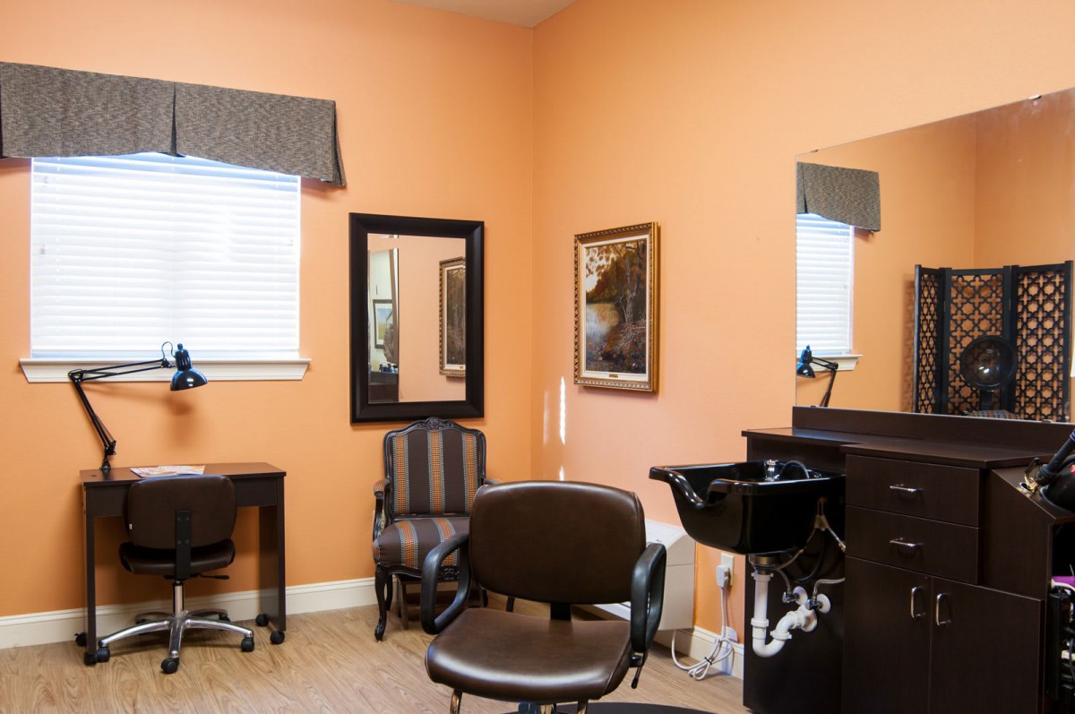 A cozy hair salon interior with chairs, mirrors, and a washing sink.