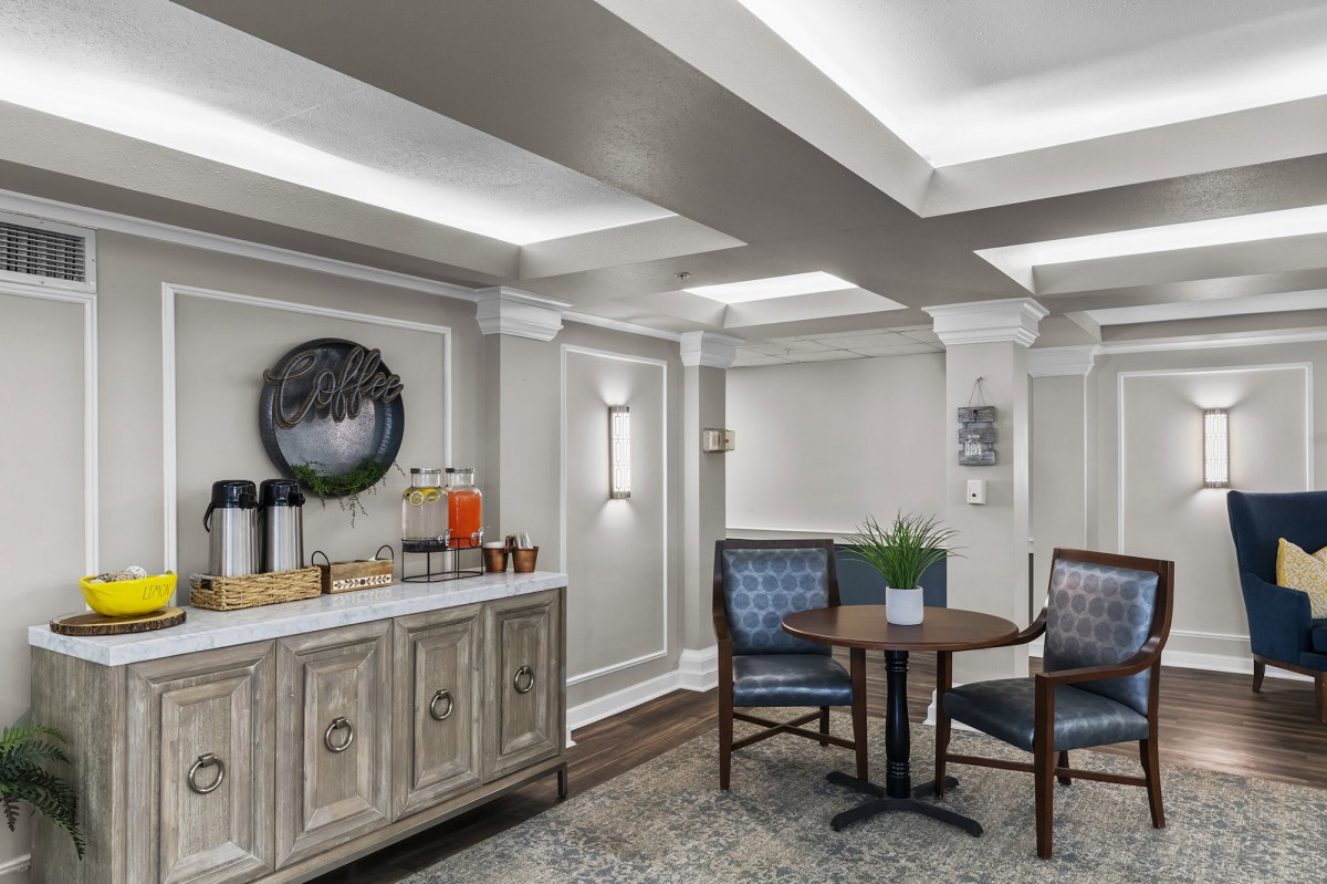A cozy lounge area with a beverage station and seating arrangements.