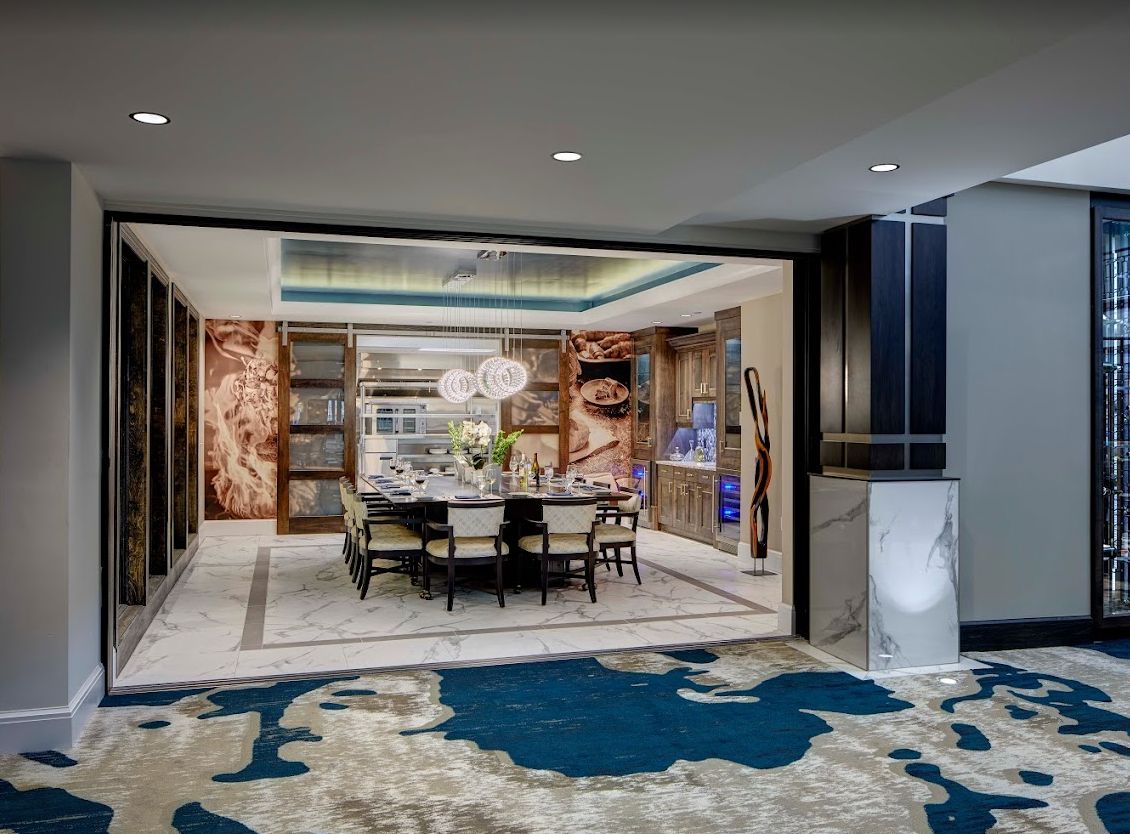 A luxurious, modern dining room featuring elegant furniture, artwork, and a stylish carpet.