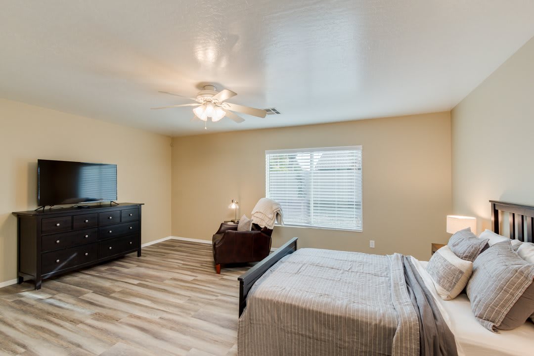 A modern bedroom with wood flooring and simple decor.