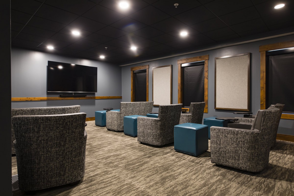 A modern lounge area with comfortable seating and a large TV.