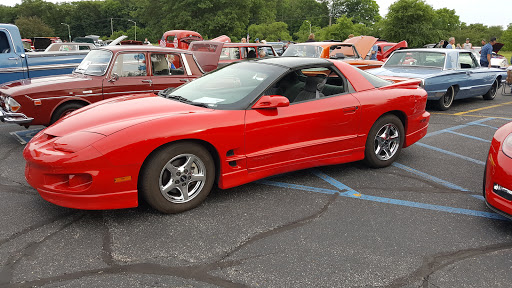 A striking red sports car parked at a classic car event.