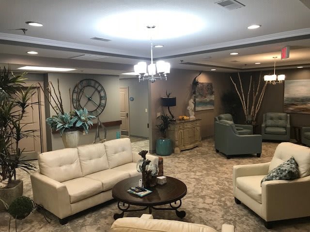 A well-decorated living room with comfortable sofas, a coffee table, and a large wall clock.