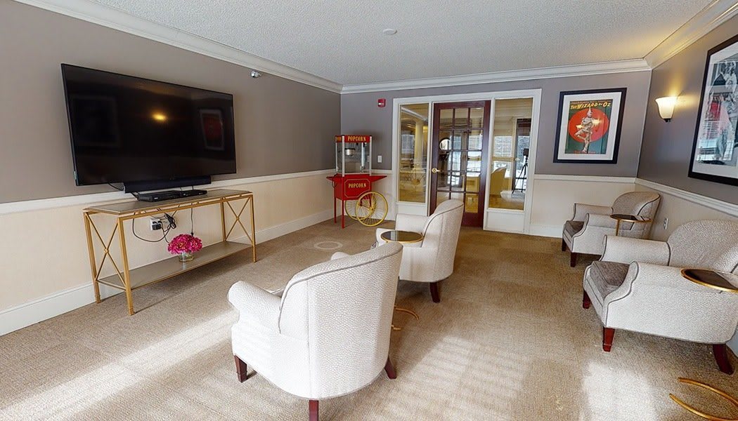 Cozy living room with comfortable seating, a large TV, and a popcorn machine for entertainment.