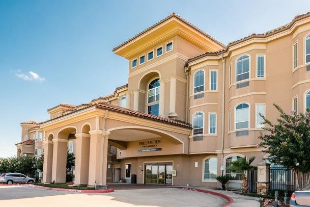 A modern hotel building with an arched entrance and multiple windows.