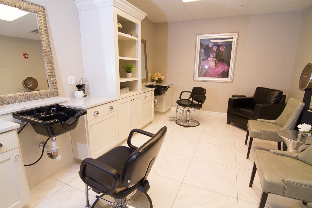 A modern hair salon with black chairs and a clean, minimalist design.