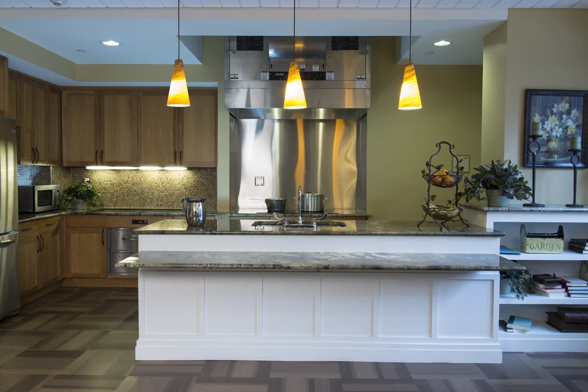 A modern kitchen interior with pendant lights and stainless steel appliances.