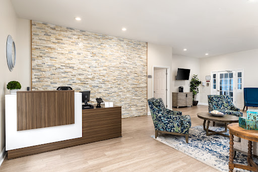 A modern reception area featuring a blend of stylish furniture and a stone accent wall.