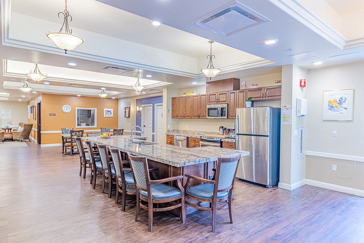 A spacious modern kitchen and dining area with a long table, multiple chairs, and stainless steel appliances.