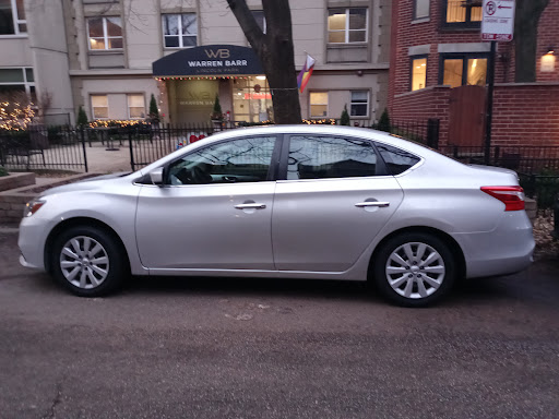 A silver sedan parked on an urban street.