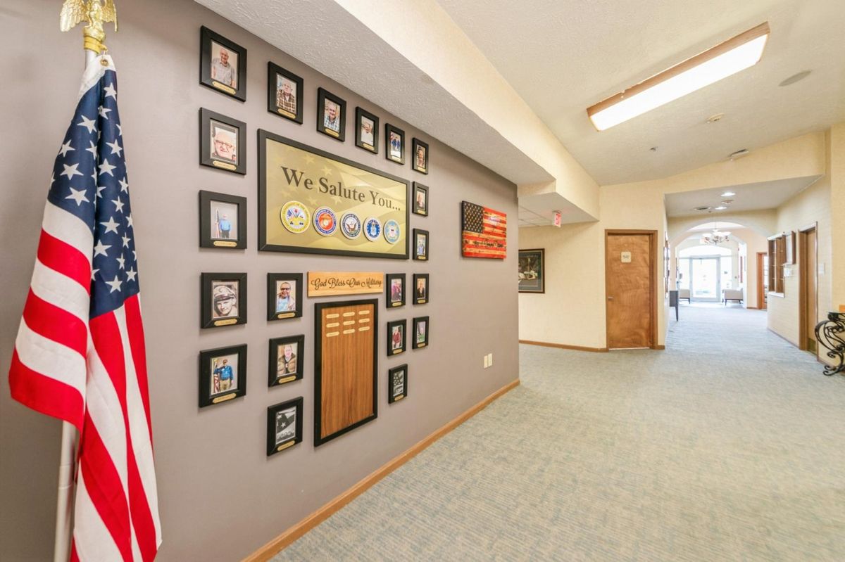 A school hallway featuring a wall with framed photos and decorative elements.