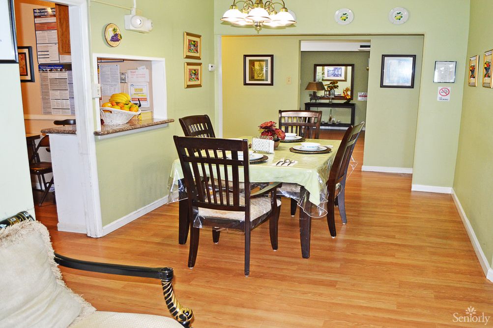 A cozy dining room with a wooden table and chairs, surrounded by tasteful decor and artwork.